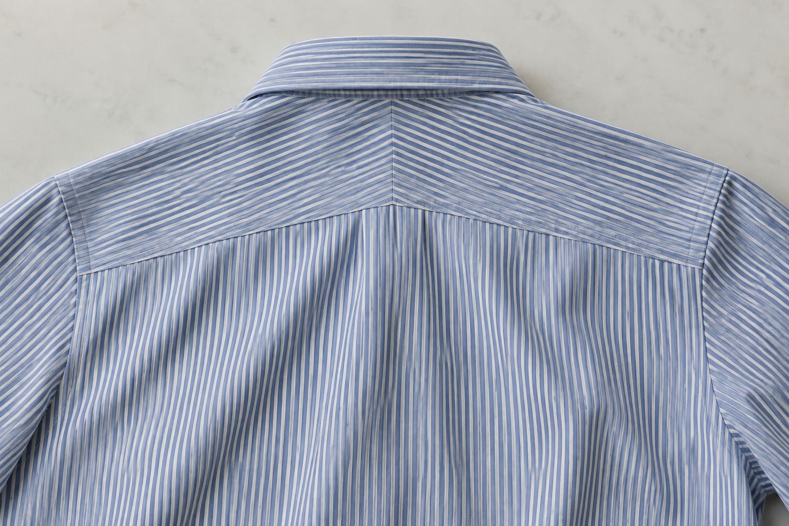 The back of a striped shirt with a two-piece split yoke whose stripes meet in a chevron.