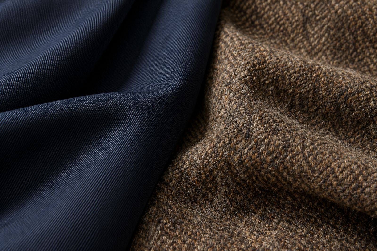 Smooth navy worsted suiting beside a coarser brown tweed, showing the difference in texture.